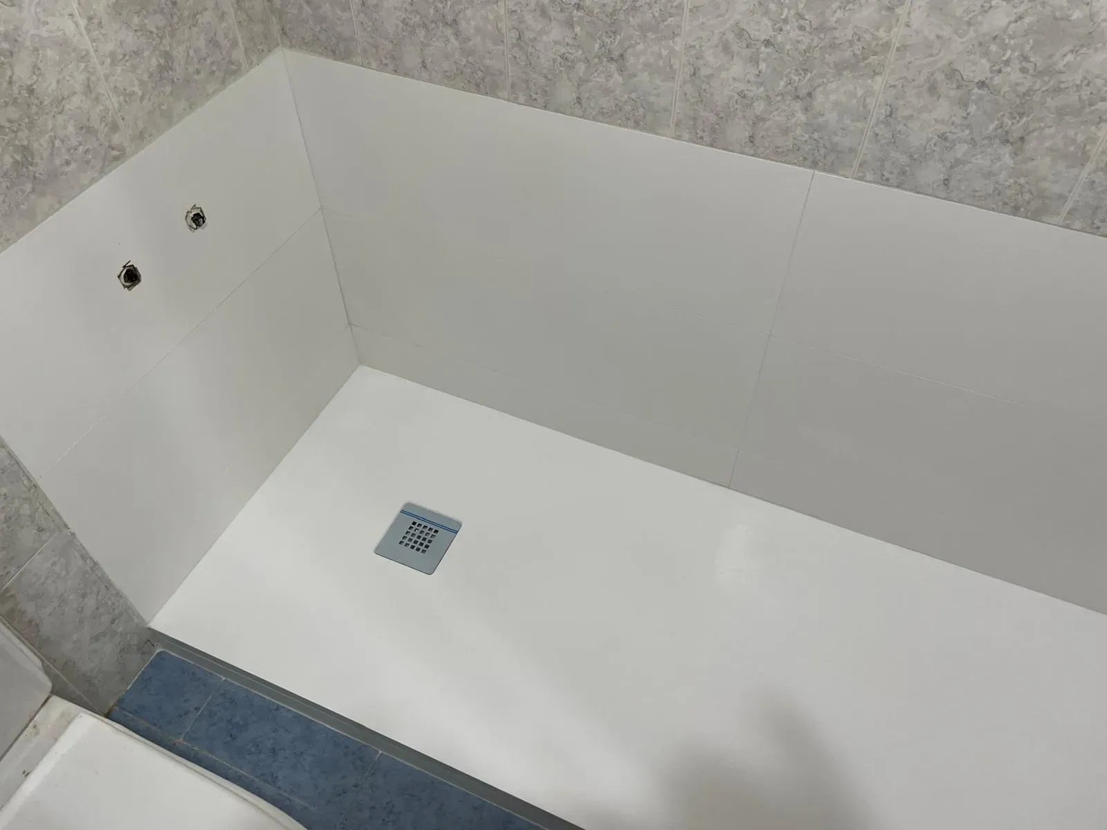 Baño con plato de ducha de obra y barras de apoyo